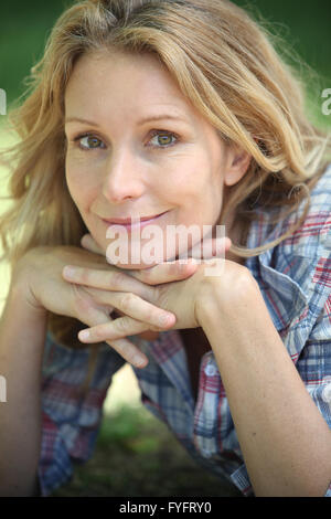 Closeup ritratto di una donna sorridente in un ambiente esterno Foto Stock