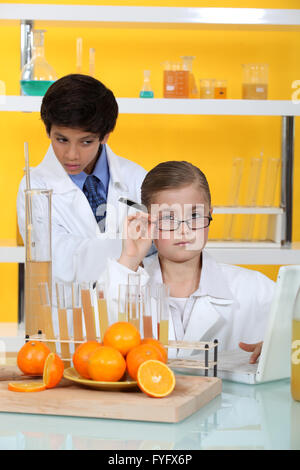 I bambini facendo esperimenti di chimica con succo di arancia Foto Stock