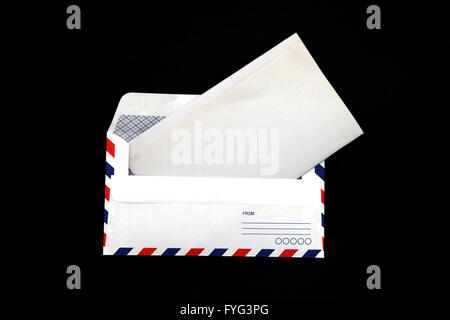 Prospettiva di isolato di posta aerea con la busta vuota carta vintage su sfondo nero. Foto Stock
