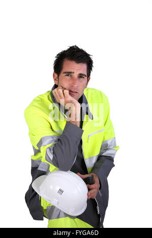 Ritratto in studio di un uomo in fluorescente abiti da lavoro e casco Foto Stock