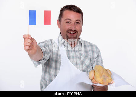 Il francese orgogliosamente sventolare la bandiera sulla sua cruda pollo francese Foto Stock