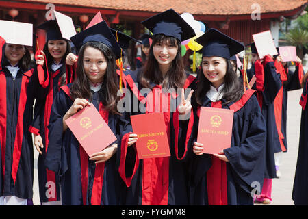 Felice studentesse che festeggiano il loro diploma presso il Tempio della Letteratura, Hanoi, Viet Nam Foto Stock