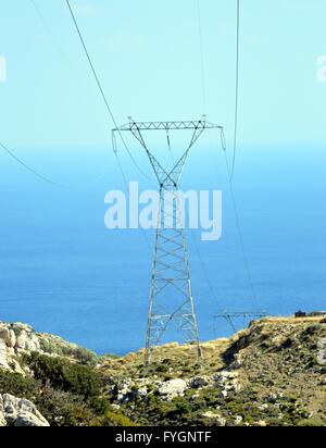 Un polo elettrico di alta tensione sullo sfondo dell'oceano. Foto Stock