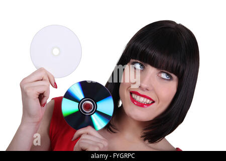 Donna che mantiene i compact disc su sfondo bianco Foto Stock