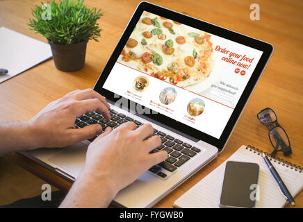 Ordine alimentare concetto. Close-up vista dall'alto di un coolhunter a ordinare una pizza con un notebook. Tutti i grafici dello schermo sono costituiti. Foto Stock