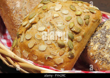 Vari tipi di pane, torte, bun, in un cestello, su un rustico, superficie in legno Foto Stock