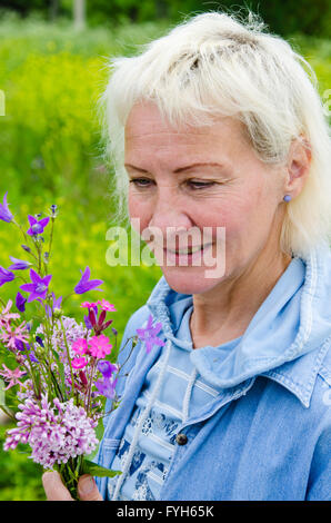 Ritratto di una donna di mezza età con un mazzo di fiori selvatici Foto Stock