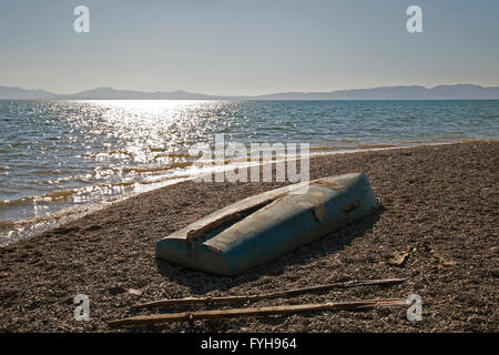 Una barca rovesciata e i remi sulla riva del lago di Issyk-Kul in Kirghizistan. Issyk-Kul è il decimo lago più grande del mondo. Foto Stock