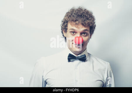 Giovani studen o imprenditore con un rosso clown naso. Studio shot. Testa e spalle. Foto Stock