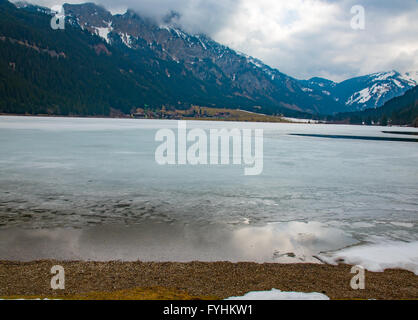 Paesaggio invernale con il lago parzialmente coperto di ghiaccio Foto Stock