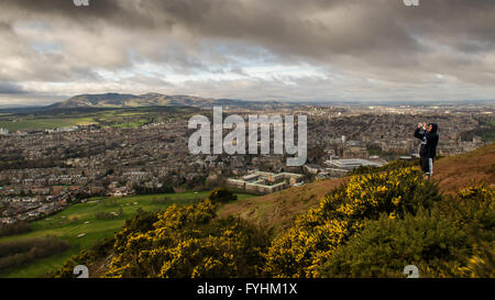 Uno studente di orologi le eclissi parziale da Arthur' Seat di Edimburgo, in Scozia. Foto Stock