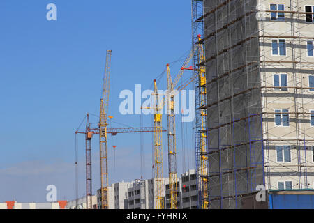 Sito in costruzione con molte gru contro il cielo Foto Stock