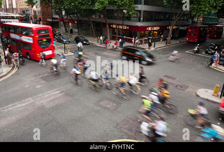 Londra, Inghilterra - Luglio 5, 2011: " commuter " ciclisti insieme fuori da una luce verde a una strada trafficata incrocio nel centro di Londra. Foto Stock