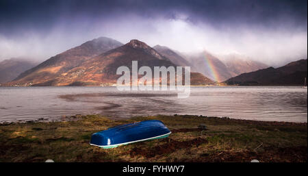 Un parziale rainbow sorge ai piedi di Glen Shiel come una tempesta passa sopra Loch Duich e le cinque sorelle di Kintail montagne. Foto Stock