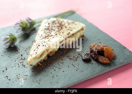 Il cioccolato bianco cheesecake su un contenitore bordo e sfondo rosa Foto Stock