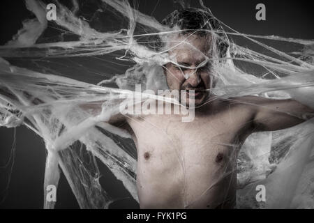 Rete.uomo aggrovigliato in enormi white spider web Foto Stock