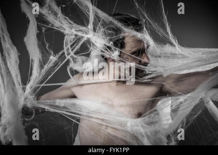 Scary rete.uomo aggrovigliato in enormi white spider web Foto Stock