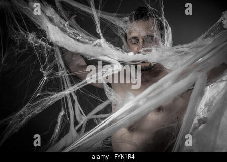 Geometria.man tangled in enormi white spider web Foto Stock