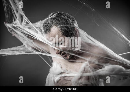 Spiderweb.man tangled in enormi white spider web Foto Stock