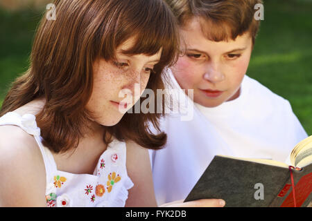 Ritratto di simpatici ragazzi la lettura di libri in ambiente naturale Foto Stock