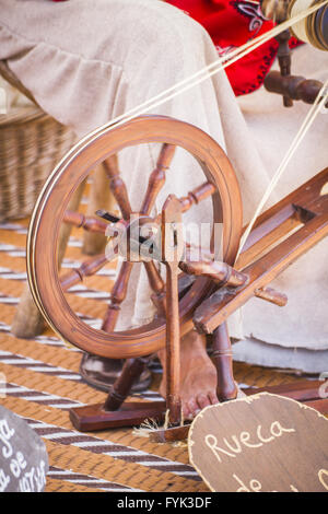 Conocchia, donna filatura su una vecchia ruota di filatura Foto Stock