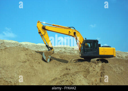Escavatore giallo, lavori di scavo in un cantiere. Foto Stock