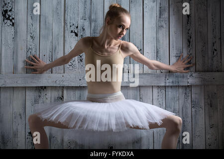 Ballerina in piedi vicino a una parete in legno Foto Stock