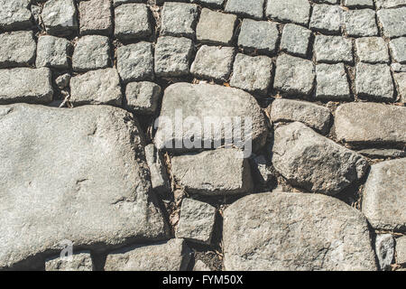 Vecchia strada lastricata e grosse pietre Foto Stock