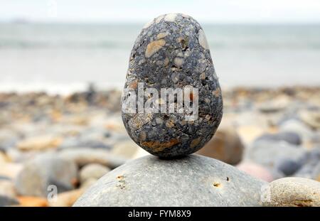 Pietre testurizzata bilanciato su una spiaggia ghiaiosa Foto Stock