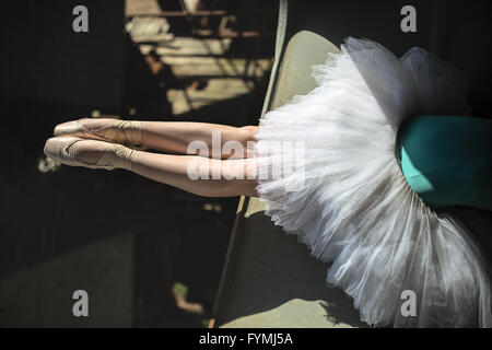 Ballerina seduta sul bordo del ponte Foto Stock