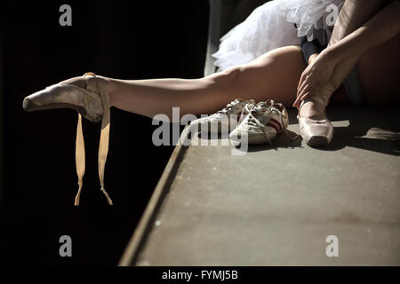 Ballerina seduta sul bordo del ponte Foto Stock