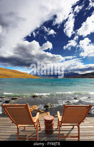 Due pieghevoli sedie di legno e un piccolo comodino Foto Stock