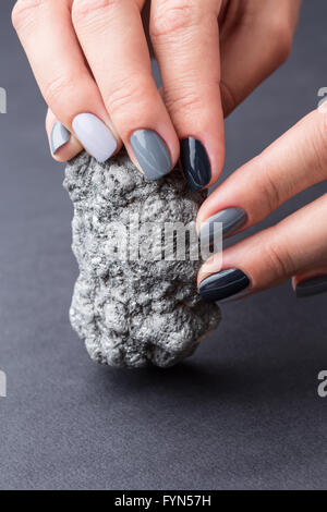 Mani femminili con trama minerale di argento Foto Stock