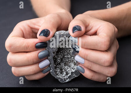 Mani femminili con trama minerale di argento Foto Stock