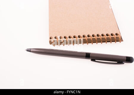 Notebook a spirale e penna pollpoint su sfondo bianco Foto Stock