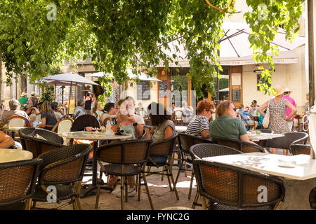 I villeggianti rilassante in un cafe' sul marciapiede, Lourmarin, Luberon, Vaucluse, Provence-Alpes-Côte d'Azur, in Francia Foto Stock