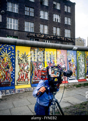 Agosto 1986, CBS cameraman TV, muro di Berlino decorate con Statua della Libertà affreschi, Berlino Ovest lato, Germania, Europa Foto Stock