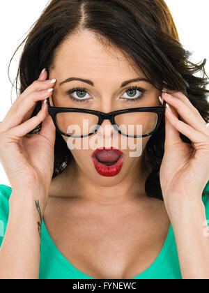 Scioccato giovane donna guardando sopra gli occhiali con la sua bocca aperta in segno di stupore isolata contro uno sfondo bianco Foto Stock