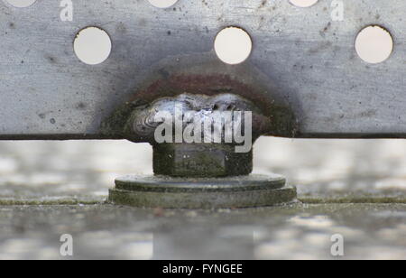 In prossimità di una giunzione di saldatura tenendo premuto il pannello di metallo con fori. Foto Stock