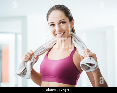 Bella donna sportivo con asciugamano di relax presso la palestra dopo il lavoro, uno stile di vita sano e concetto di fitness Foto Stock