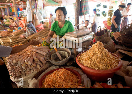 NYAUNG-U, Myanmar - Una donna vende radici e verdure a Nyaung-U Mercato, vicino a Bagan, Myanmar (Birmania). Il mercato è anche noto come Mani Sithu mercato. Foto Stock