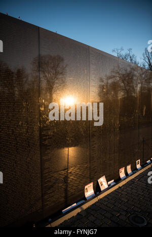 WASHINGTON DC, Stati Uniti — il muro di granito nero del Vietnam Veterans Memorial, inciso con oltre 58.000 nomi, si erge come un solenne omaggio ai militari americani e ai militari che hanno perso la vita nella guerra del Vietnam. Il design minimalista di Maya Lin serve da specchio poignante, riflettendo sia i visitatori che le bellezze naturali circostanti del National Mall, racchiudendo la memoria collettiva e l'impatto della guerra del Vietnam sulla società americana. Foto Stock