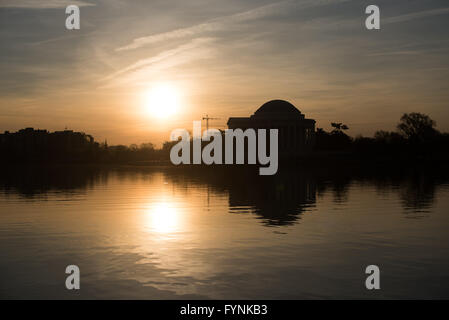 WASHINGTON DC, Stati Uniti - Il sole sorge dietro il Jefferson Memorial e si riflette sulle acque tranquille del bacino di marea a Washington DC. Foto Stock