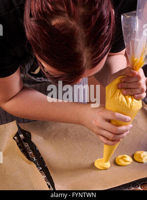 Vassoio di tubazioni di amaretti. La donna rende amaretto Foto Stock