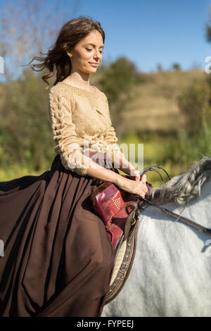 Bella ragazza in sella ad un cavallo bianco Foto Stock