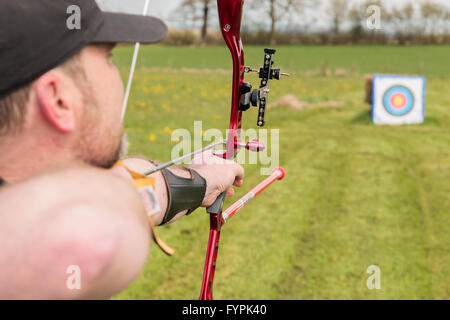 Archer praticare il tiro con l arco di campo preparazione per perdere la sua freccia Foto Stock