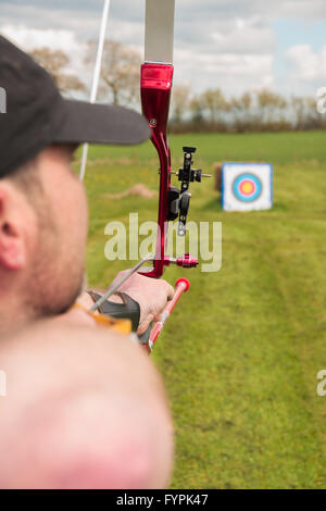 Archer praticare il tiro con l arco di campo preparazione per perdere la sua freccia Foto Stock