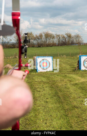 Archer praticare il tiro con l arco di campo preparazione per perdere la sua freccia sul bersaglio Foto Stock