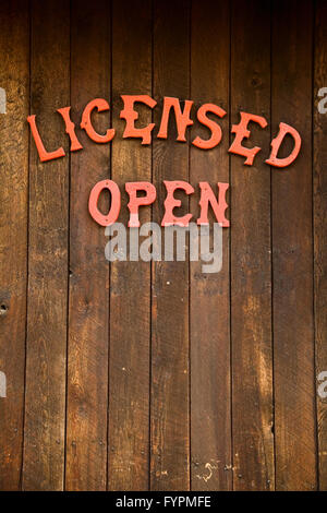 Rosso 'Licenza' e 'open' segno sul lato di un rustico ristorante in legno edificio in Banff, Canada. Foto Stock