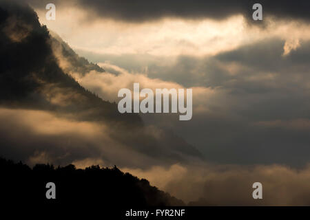 La nebbia sul fianco della montagna sopra la valle dell'Inn, il sole che splende attraverso le nuvole, Stans, Tirolo, Austria Foto Stock